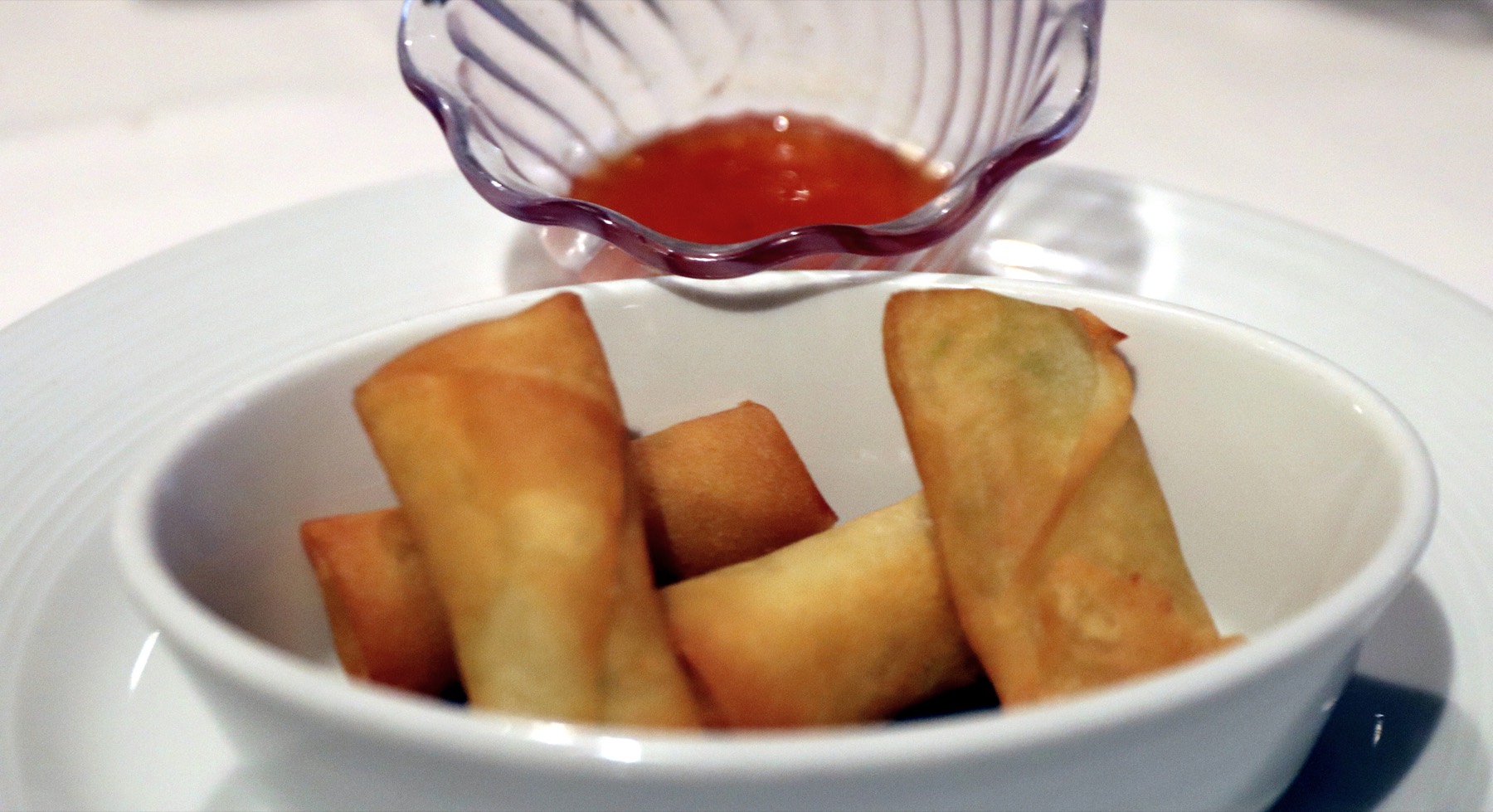 Golden crispy lumpia stacked on a serving plate